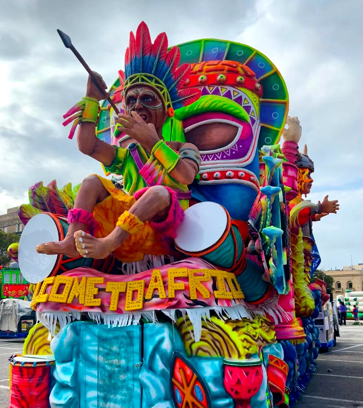 Vibrant carnival float featuring a tribal drummer sculpture at the Malta Carnival parade in Valletta
